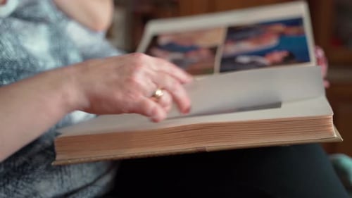 Mujer mayor mirando de cerca un viejo álbum de fotos