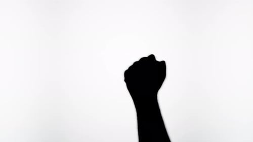 Silhouette of Fist Pumping Against White Background