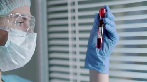 Medical Worker Examines COVID-19 Test Tube Close Up