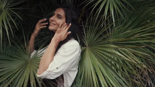 Smiling Woman Posing with Tropical Leaves