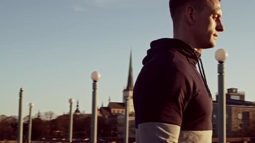 Man Doing Bicep Curls Outdoors at Sunset
