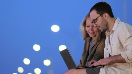 Male And Female College Students Working On Laptop In Library