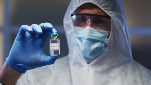 Scientist Holding COVID-19 Vaccine Vial in Lab