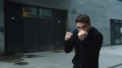 Young Man Shadow Boxing in Urban Setting