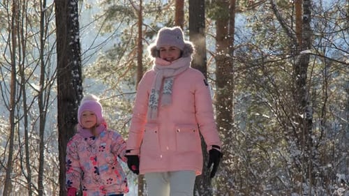 Woman and Child Walking in Snowy Winter Forest