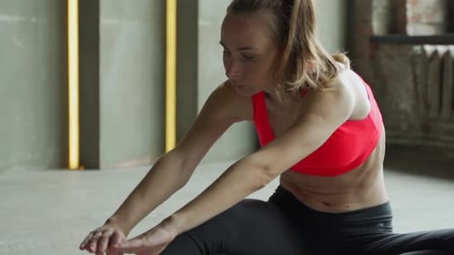 Young Woman Practicing Yoga Stretching at Gym