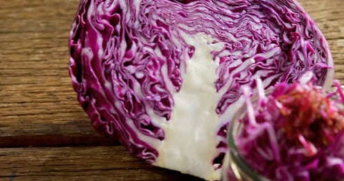 Chopped and halved red cabbage on wooden table