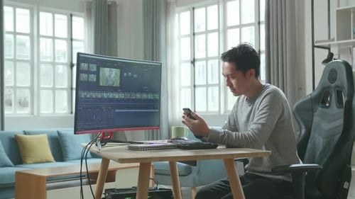 Man Using Mobile Phone While Working At Home