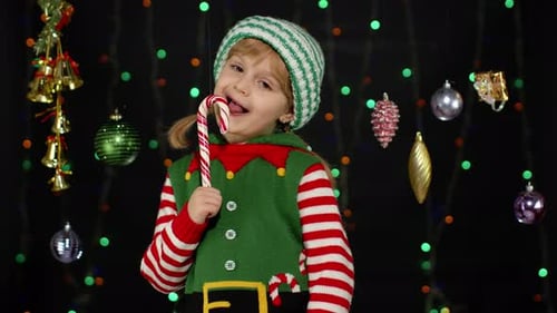 Cute Child in Elf Costume with Candy Cane