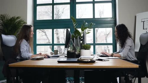 Zwei kaukasische Architektinnen, die im Büro arbeiten.
