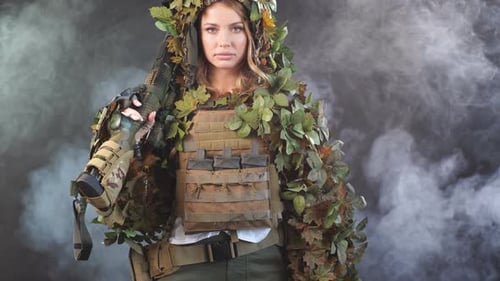 Woman in Tactical Vest and Ghillie Suit Holding Rifle