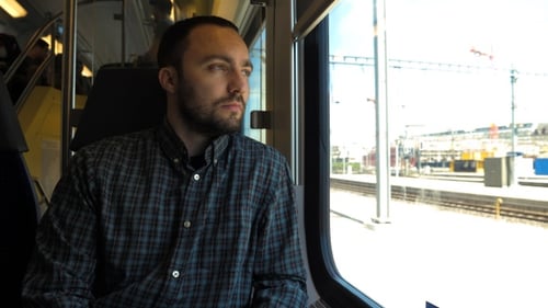 Young man looking out the window while riding a train.