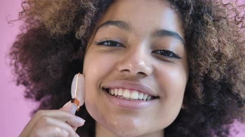 Woman Using Facial Roller for Beauty Treatment