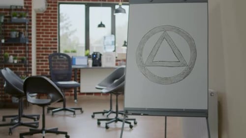 Empty Room with Aa Meeting Sign on White Board and Chairs in Circle