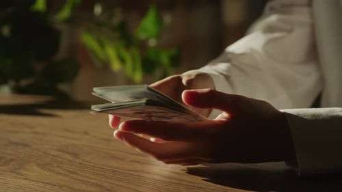 Handheld Close Up of Caucasian Woman Hands Counting Money in 100 Dollar Bill Banknote