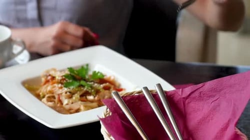 Close-up of a Woman Eating Vegetable Salad with Baked Fish in a Restaurant