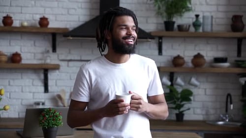 Young Adult Man Enjoys Coffee in Kitchen