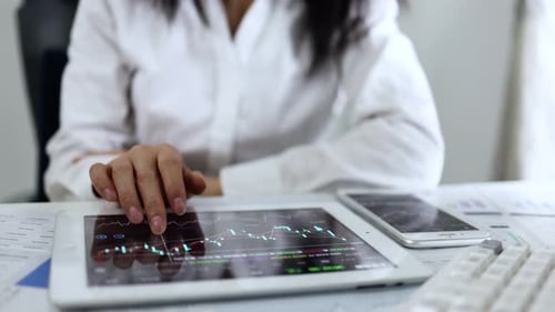 Adult Using Tablet to Analyze Charts