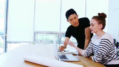 Team Discussing Project on Laptop in Modern Office