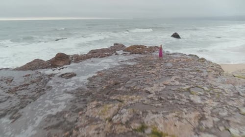 Woman Standing On The Rocky Shore