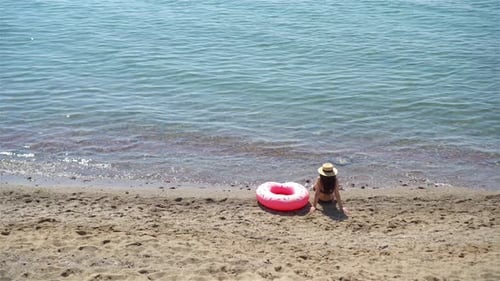 Junge Frau mit Hut im Strandurlaub