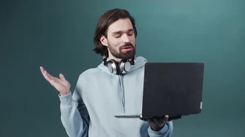 Man Chatting on Laptop Wearing Headphones