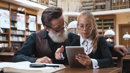 Child and Adult Read Tablet in Library