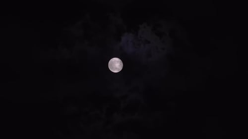 Ethereal Full Moon Shining Through Night Clouds