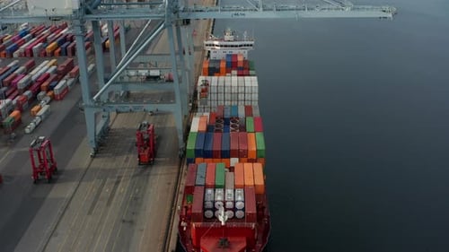 Top ein Containerschiff, Turmkran, Gabelstapler und das ruhige Meerwasser