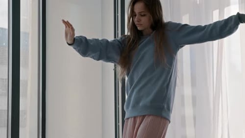 Woman Dances Gracefully Indoors Near a Window
