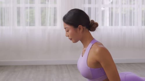 De perto. Mulher asiática praticando ioga, exercício Cobra