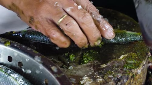 Frau schneidet Fisch auf einem Fischmarkt
