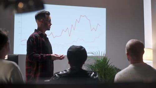 Business Meeting. Office Team Analyzes Business Growth. Young Man Interested In Audience. On Screen