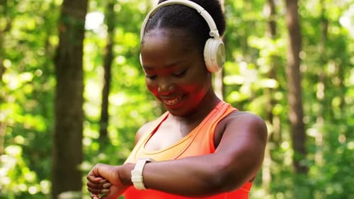Woman Checks Smartwatch During Forest Workout