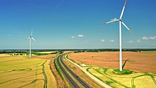 Wind turbines near highway in summer, Poland, aerial view