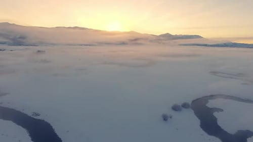 Flying over winter landscape in Wyoming moving over winding river