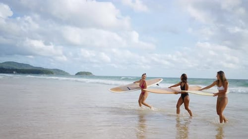 4K Group of Asian woman holding surfboard walking together on the beach in sunny day.