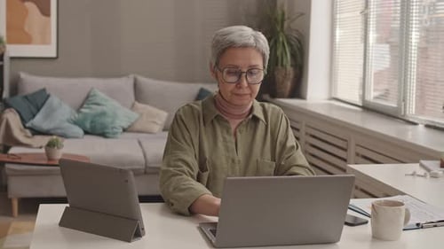 Woman Working on Laptop Computer at Home Office