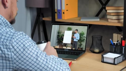 Businessman in Office Looks Laptop Listen Online Business Course Drink Coffee