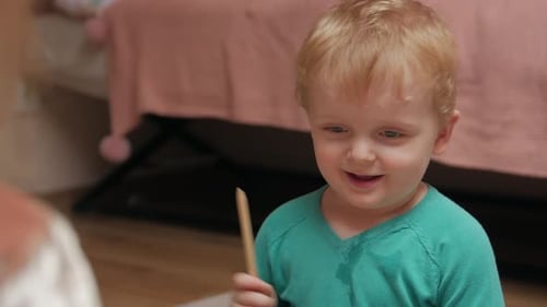 Cute Child Plays Drum Set at Home