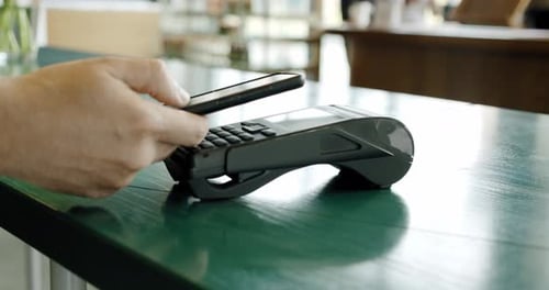 Kontaktloses Bezahlen für die Verwendung von Paying Per Smartphone NFC-Technologie im Café, Nahaufnahme