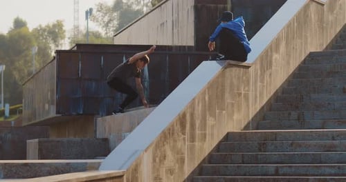 Parkour in the City. Young Man Jumps on the Steps of a Building and Does a Backflip in the Air.