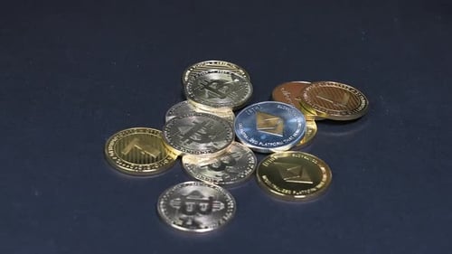 Pièce Monero tombant sur d'autres pièces de crypto-monnaie sur une surface bleue.