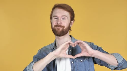 Man with Red Hair Makes Heart Shape with Hands