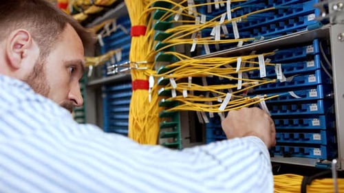 Man Connecting Cables in Server Room, Close Up