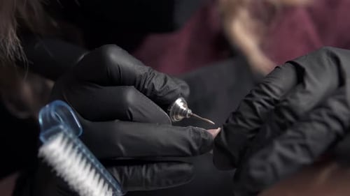 Manicurist Filing Nails in Beauty Salon