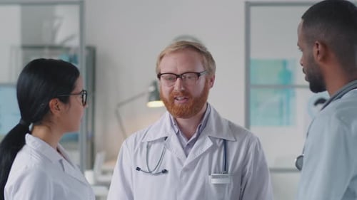 Team of Diverse Doctors Talking at Work in Medical Office