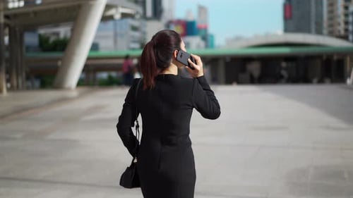 business woman walking and talking with mobile phone in the city