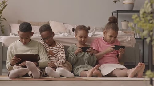 Children Using Tablets and Smartphones in Bedroom