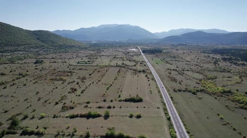 Empty Asphalt Road on the Plateau Between Green Fields Highland Way Aerial View